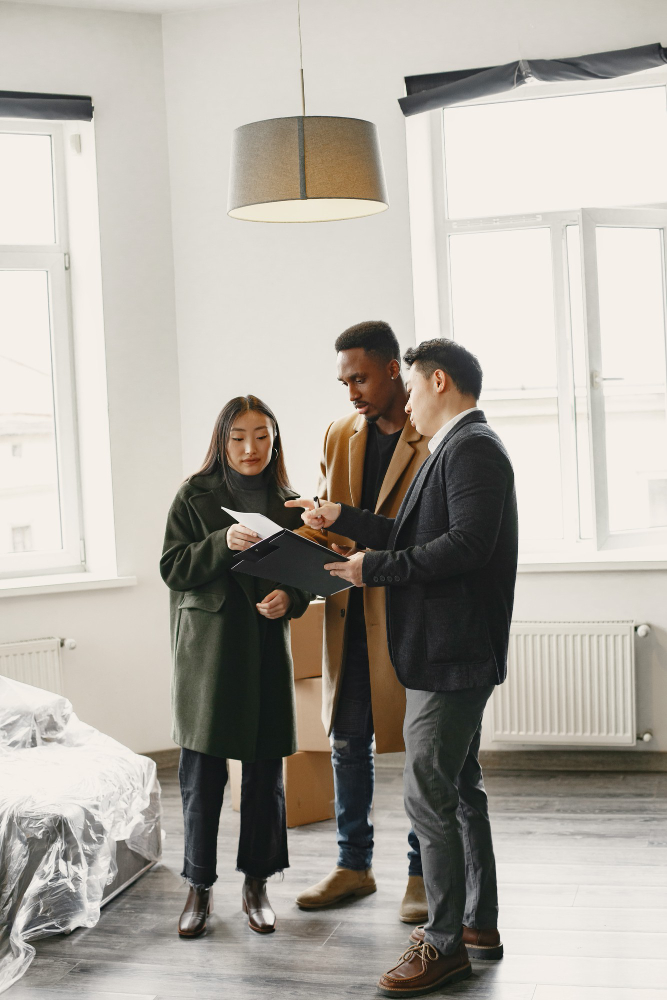 young couple buying a home signing documents with letting agent